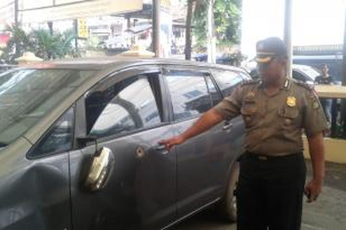 Kapolsek Metro Tamansari Ajun Komisaris Besar Tri Suhartanto, menunjukan lubang bekas peluru di Mobil Toyota Innova milik pelaku pencurian, Senin (30/6/2014).