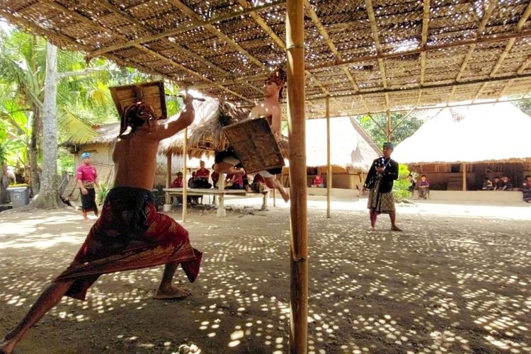 Suasana saat dua pemuda menampilkan seni adu ketangkasan bernama tarian peresean di Desa Wisata Sasak Ende di Sengkol, Pujut, Kabupaten Lombok Tengah, Selasa (6/12/2022).