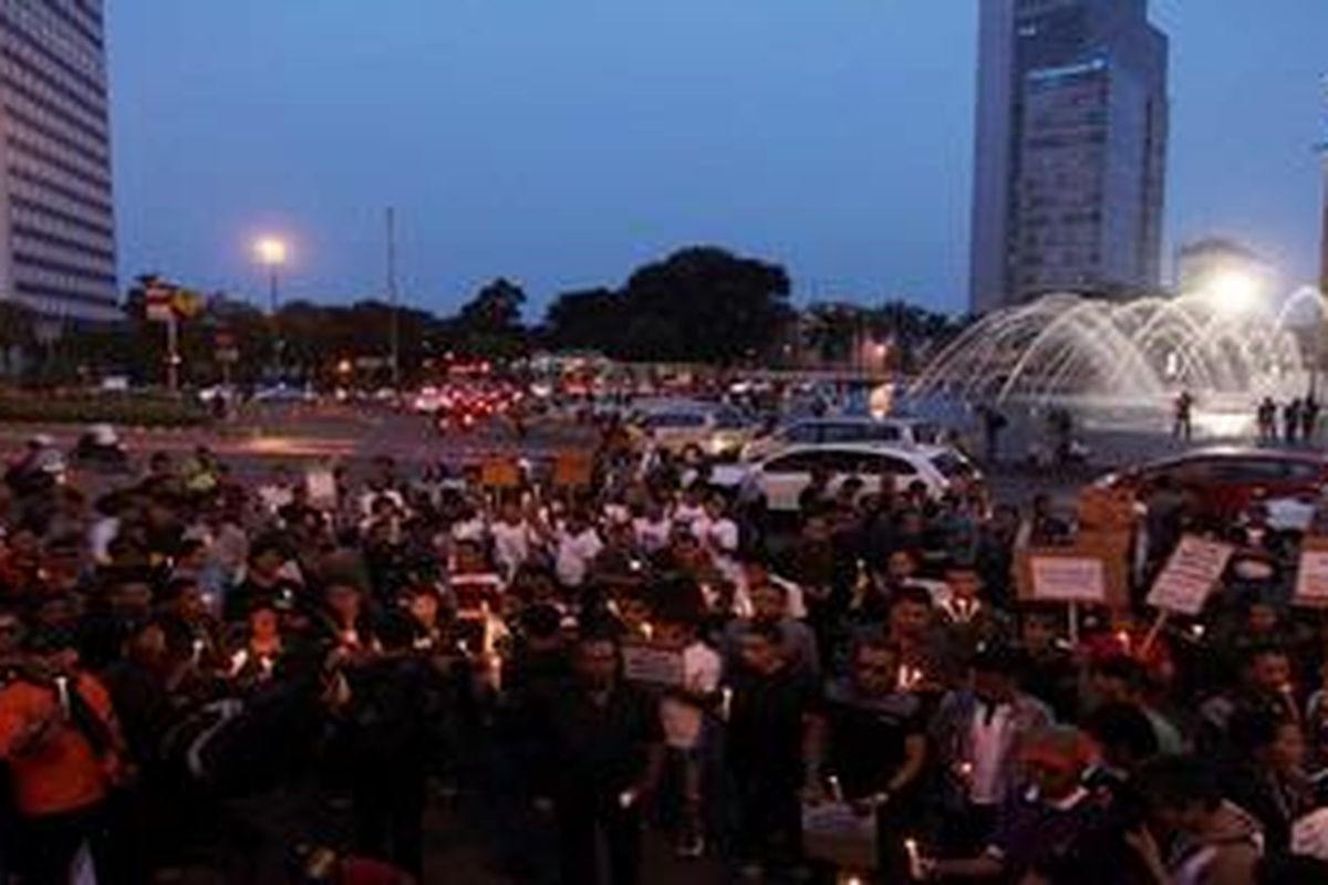 Ratusan warga yang tergabung dalam Solidaritas Kemanusiaan untuk Korban Pembantaian di Yogyakarta menggelar aksi demo  Kawasan Bundaran Hotel Indonesia (HI), Jakarta, Minggu (24/3/2013). Mereka dengan berpakaian hitam dan membawa lilin di tangan menuntut dan mendesak pemerintah serta aparat berwenang untuk mengusut tuntas dan menyeret pelaku penembakan empat napi di dalam Lapas Cebongan, Sleman, Yogyakarta beberapa waktu yang lalu.  