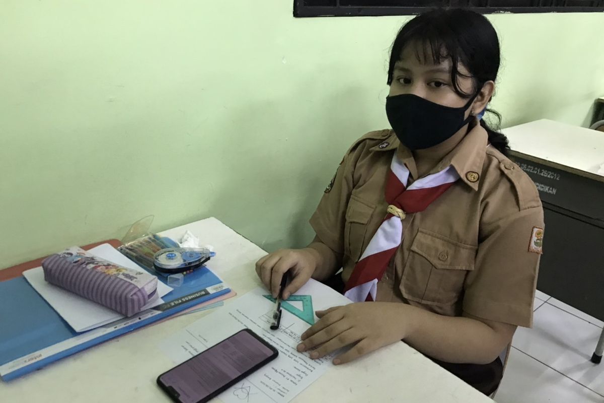 Mediana (15), siswa kelas X SMK Negeri 15, Kebayoran Baru, Jakarta Selatan mengikuti uji coba belajar tatap muka pada Rabu (7/4/2021) pagi.