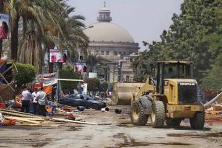 Buldoser membersihkan puing setelah pasukan keamanan membersihkan area/kamp pendukung Presiden Mesir terguling Muhammad Mursi, di depan Universitas Kairo, Giza, Kairo, Mesir, 14 Agustus 2013.