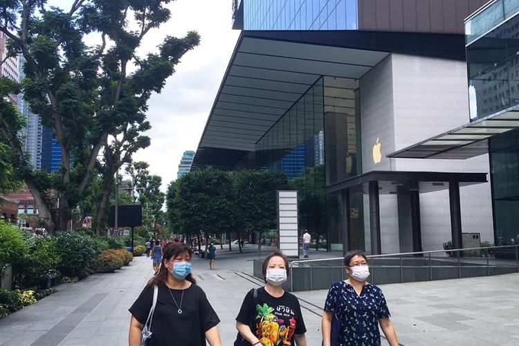 Ibu-Ibu terlihat memakai masker ketika berjalan di dekat Apple Store di surga belanja Orchard Road, Singapura, Sabtu (04/04/2020). Meningkatnya kasus transmisi lokal di negeri  “Singa” membuat pemerintah Singapura menghimbau warganya untuk memakai masker ketika keluar rumah