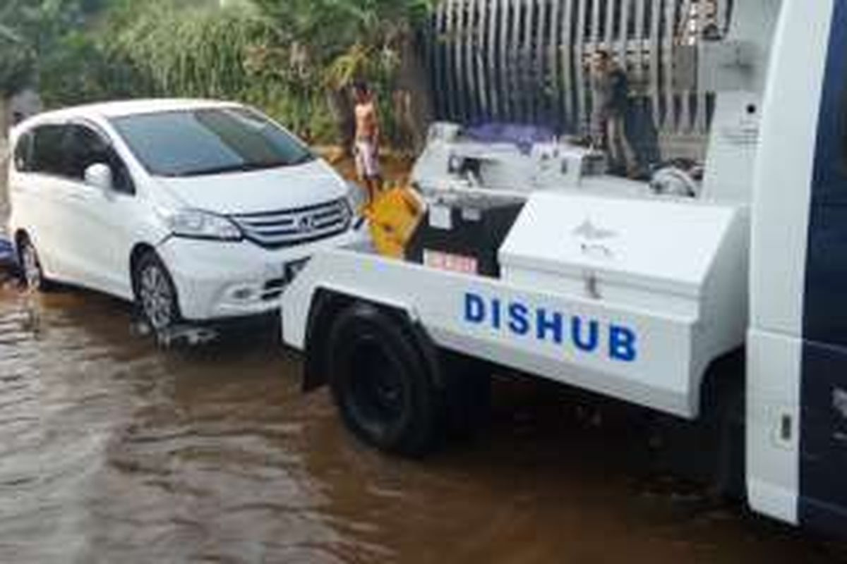 Sabtu (4/6/2016), mobil derek Dinas Perhubungan menderek mobil yang terendam banjir 
