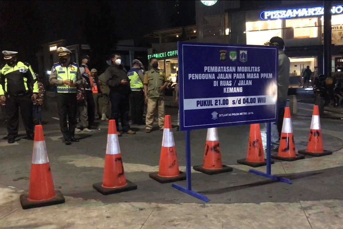 Police man a roadblock sealing off Jalan Raya Kemang, one of ten thoroughfares sealed off by the Jakarta Metropolitan Police from 9 pm to 4 am on Monday  (21/6/2021)