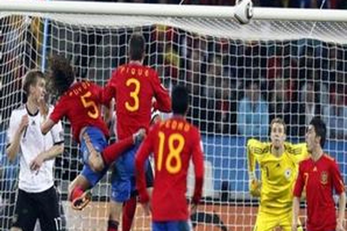 Spains Carles Puyol, second from left, scores a goal past Germany goalkeeper Manuel Neuer, second right, during the World Cup semifinal soccer match between Germany and Spain at the stadium in Durban, South Africa, Wednesday, July 7, 2010.