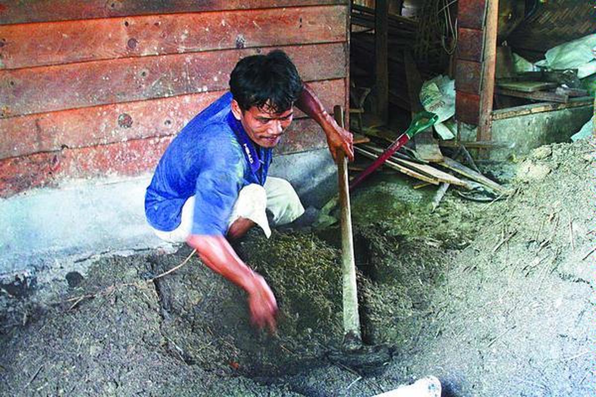 Namora Manalu, petani jeruk di Desa Lobu Tua, Kecamatan Siborongborong, Kabupaten Tapanuli Utara, mengaduk campuran kompos untuk pembuatan pupuk organik, Jumat (20/6). Pupuk organik yang dibuat Namora merupakan campuran kompos, ikan busuk, dedak, dan sekam yang dicampur dengan bakteri pengurai. Petani di Sumatera Utara seperti Namora sekarang ini mulai beralih menggunakan pupuk organik akibat menghilangnya pupuk bersubsidi dan mahalnya pupuk kimia nonsubsidi.  