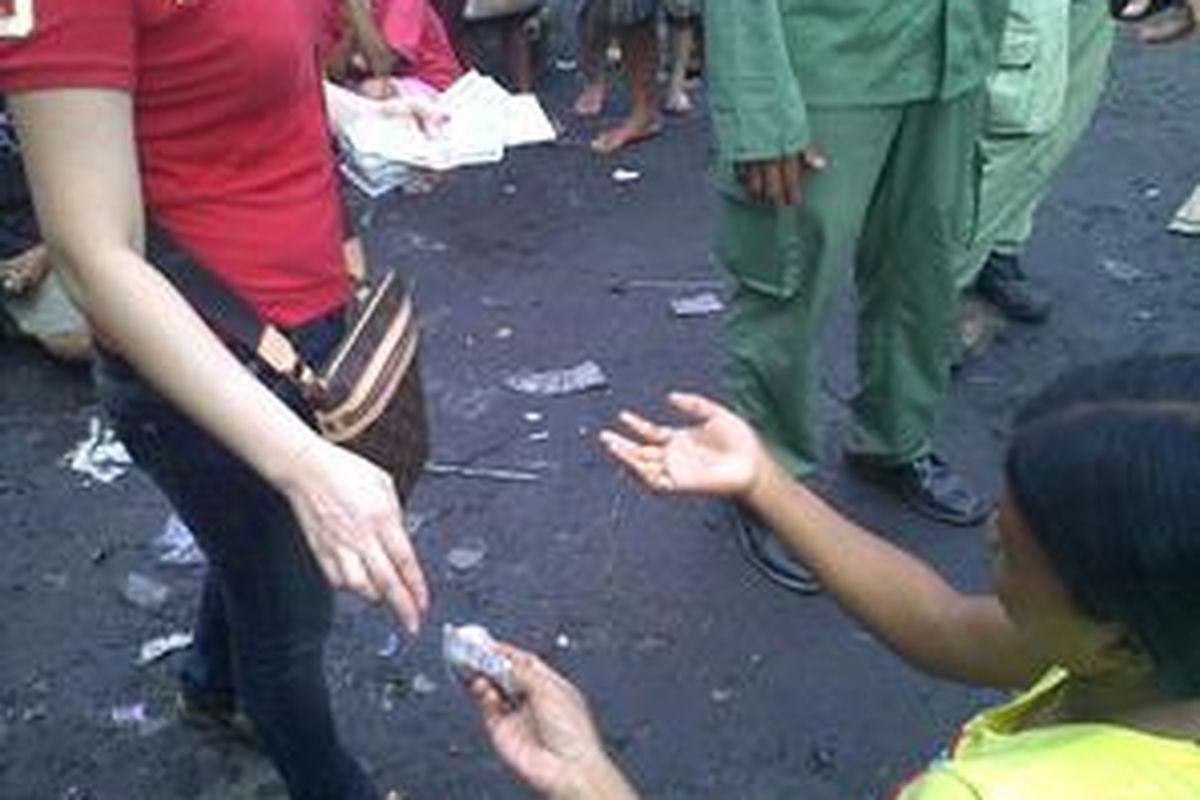 Seorang petugas klenteng membagikan angpao kepada ratusan pengemis di klenteng Petak Sembilan, Glodok, Jakarta Barat, Minggu (14/2/2010).