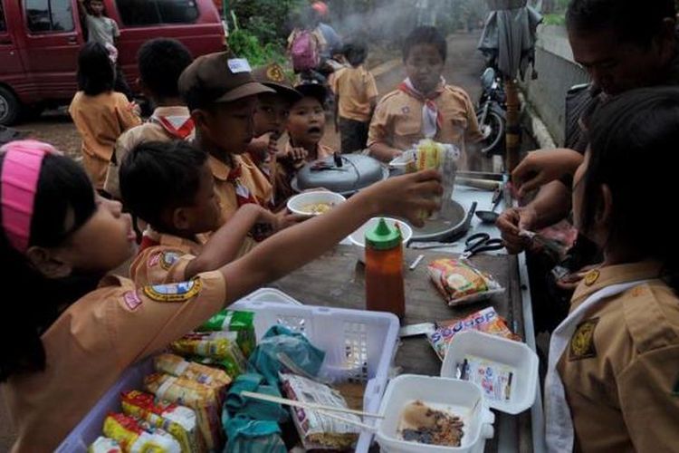 Murid-murid SD membeli jajanan saat jam istirahat di sekitar sekolah mereka di kawasan Kuningan, Jakarta, Rabu (20/2/2013). Jajanan sekolah yang tidak terjamin kebersihan dan keamanannya berpotensi menjadi penyebab gangguan kesehatan bagi anak-anak.
