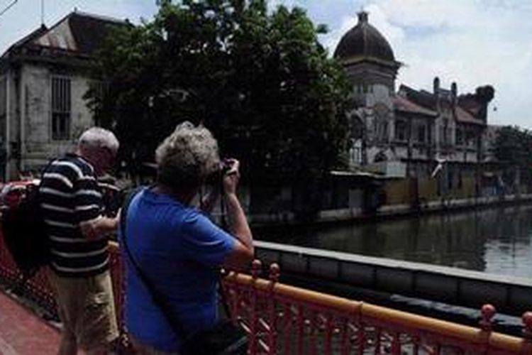 Pasangan turis dari Belanda memanfaatkan waktu singgah kapal pesiar yang membawa mereka dengan berjalan-jalan di Kawasan Kota Lama, Kota Semarang, Jawa Tengah, Jumat (6/1/2012). Potensi wisata Kota Semarang seperti Kawasan Pecinan dan Kota Lama hingga saat ini belum tergarap dengan maksimal dalam menyambut wisatawan yang datang.