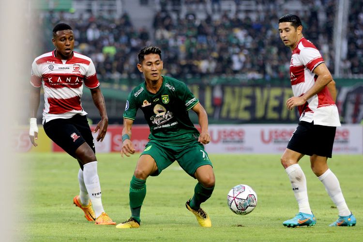 Pemain Persebaya Surabaya Rizky Dwiyan Aprilyanto dijaga pemain Madura United Hugo Gomes dan Esteban Viscarra saat pertandingan pekan 4 Liga 1 2022-2023 yang berakhir dengan skor 2-2 di Stadion Gelora Bung Tomo Surabaya, Minggu (14/8/2022) sore.