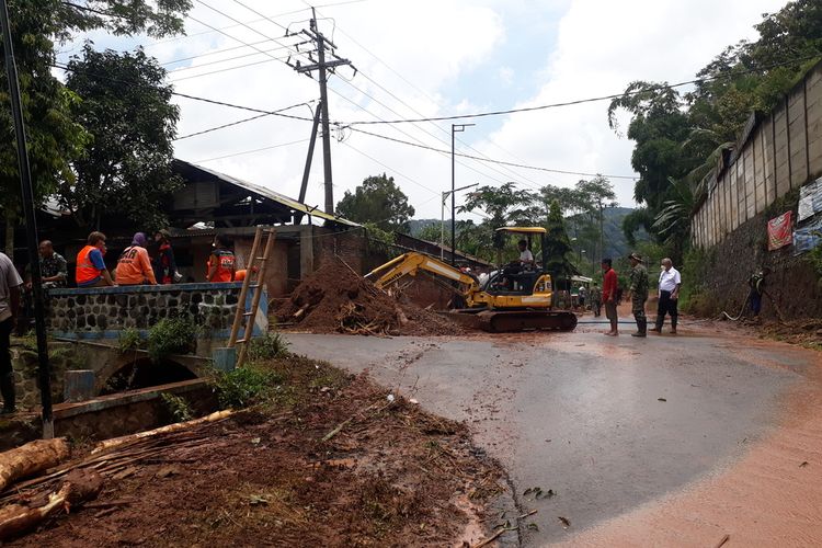 Personel gabungan membersihkan sisa material akibat banjir bandang di Desa Srigading, Kecamatan Lawang, Kabupaten Malang.