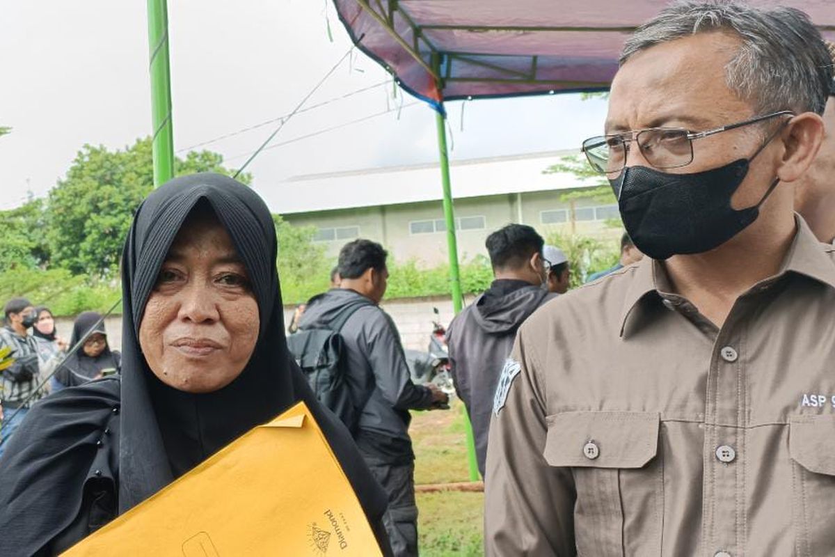 Istri dari Abdul Hamid alias Pak Ogah bersama dengan Ketua ASP 1993-1994 Iptu Suhar (kanan) saat prosesi pemakaman sang suami di TPU Jatisari, Jatiasih, Kota Bekasi, Kamis (29/12/2022).