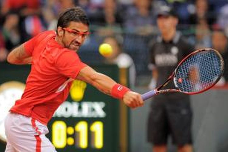 Petenis Serbia, Janko Tipsarevic mengembalikan bola ke arah Milos Raonic dari Kanada, pada pertandingan kedua, hari pertama di Belgrade, Jumat (13/9/2013).