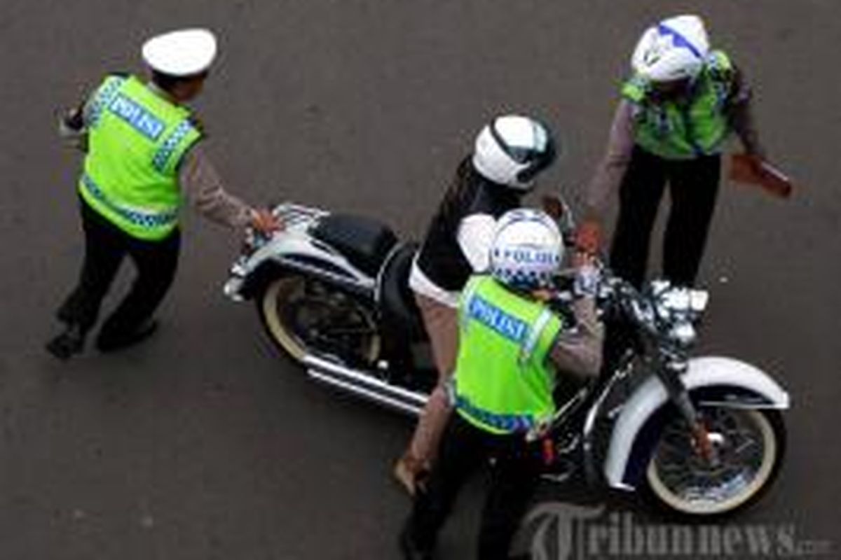 Seorang pengendara Harley Davidson bernomor polisi B 6168 ESG untuk ditilang karena melintasi Jalan MH Thamrin, Jakarta Pusat, yang merupakan kawasan terlarang sepeda motor, Minggu (18/1/2015).