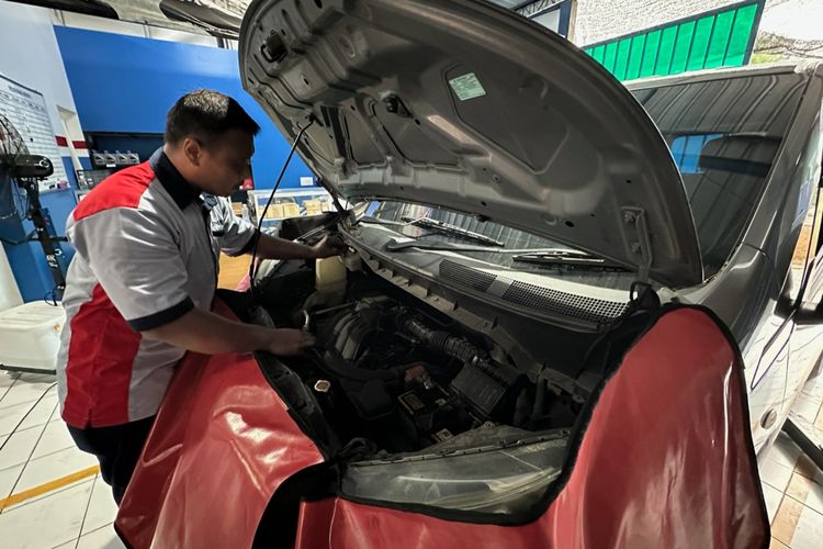 Seorang montir sedang memeriksa mobil pelanggannya di Bengkel Plat AD Auto Service, Mojolaban, Sukoharjo, Jawa Tengah pada Selasa (11/11/2024).