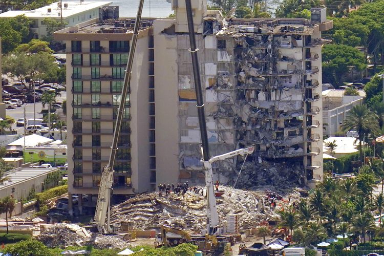 This aerial image shows an oceanfront condo building that partially collapsed three days earlier, resulting in fatalities and many people still unaccounted for, in Surfside, Fla., Sunday, June 27, 2021. (AP Photo/Gerald Herbert)