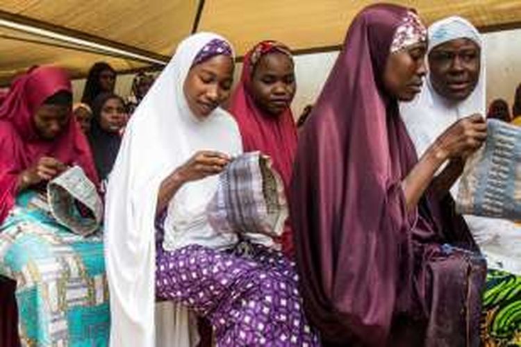 Kaum perempuan Nigeria korban Boko Haram sedang membuat hula, topi tradisional etnis Hausa untuk dijual. Sebagian lain terpaksa melacur karena tidak ada kemampuan lain untuk menghasilkan uang.