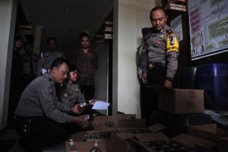 Wakapolres Semarang Kompol Sunarno (paling kanan) sedang memeriksa puluhan botol barang bukti miras hasil razia dalam operasi lilin candi 2015.