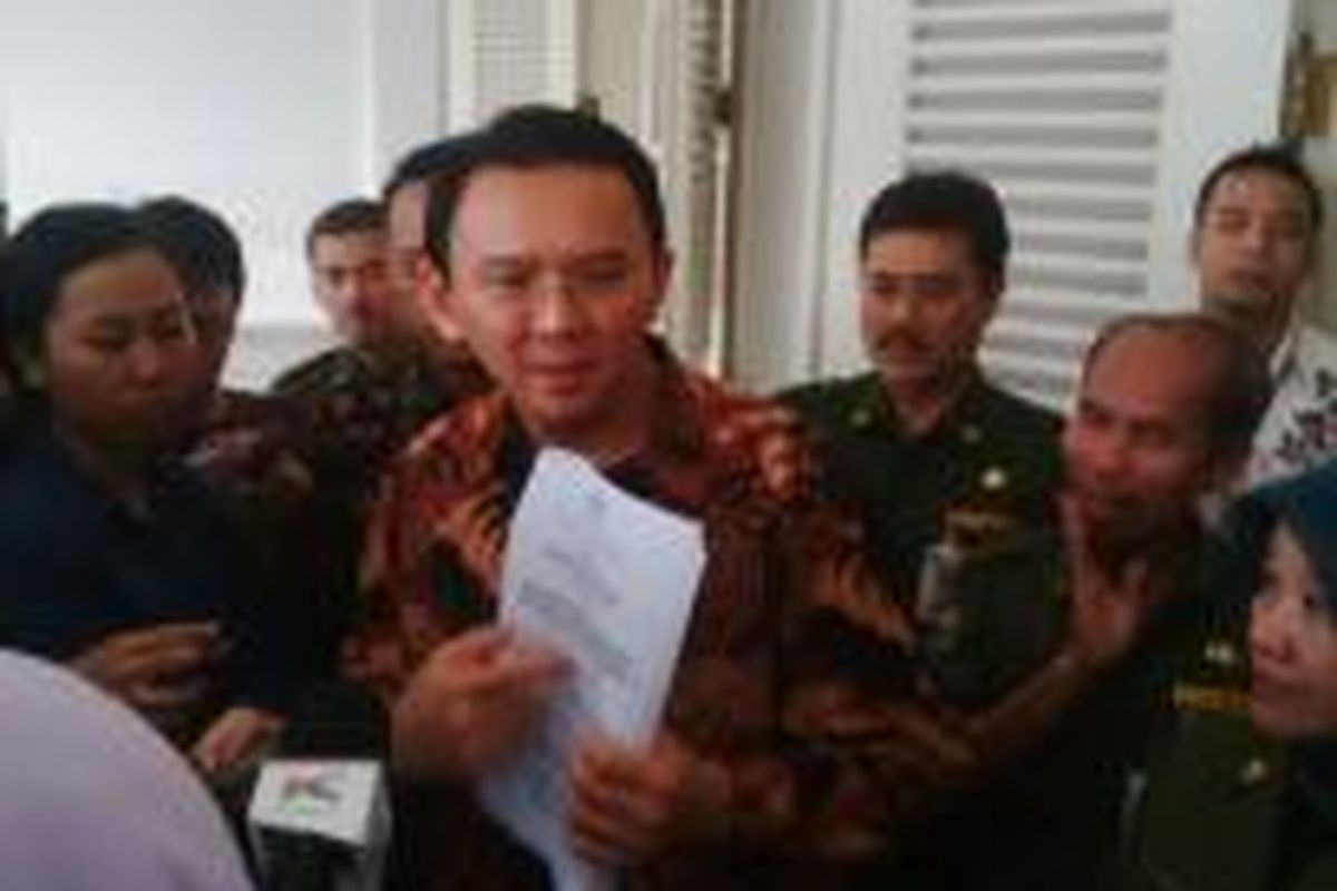 Gubernur DKI Jakarta Basuki Tjahaja Purnama menunjukkan surat penolakan DPRD menerbitkan Perda APBD 2015, di Balai Kota, Senin (23/3/2015). 