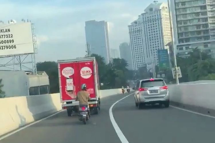 Pemotor hindari polisi dengan bersembunyi di balik mobil