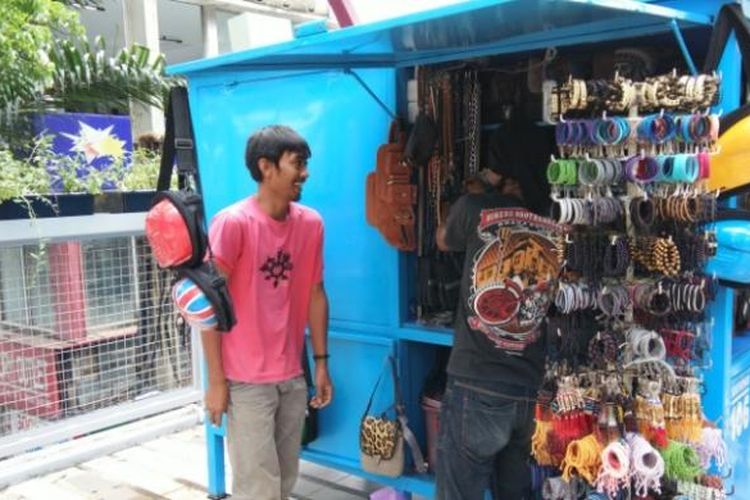 Salah seorang pedagang aksesori saat menata dagangannya di Skywalk Cihampelas, Bandung,  Kamis (2/2/2017).