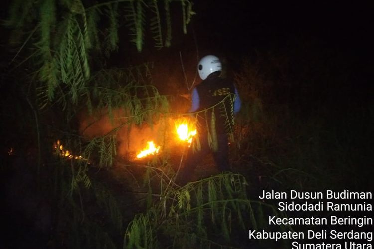 Petugas Avsec Bandara Kualanamu saat memadamkan api yang membakar ilalang di areal daerah keamanan terbatas (DKT) Perimeter Selatan di dekat Pos 9 Bandara Kualanamu, Deli Serdang, Sumatera Utara, sempat terbakar, Senin (17/7/2023) malam 
