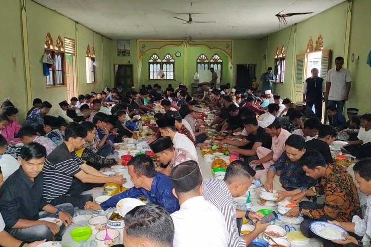 Warga menikmati Makan Bajambau di Dusun Jawi Jawi, Desa Persiapan Jawi Jawi, Kecamatan Kampa, Kabupaten Kampar, Riau, Jumat (8/3/2024).