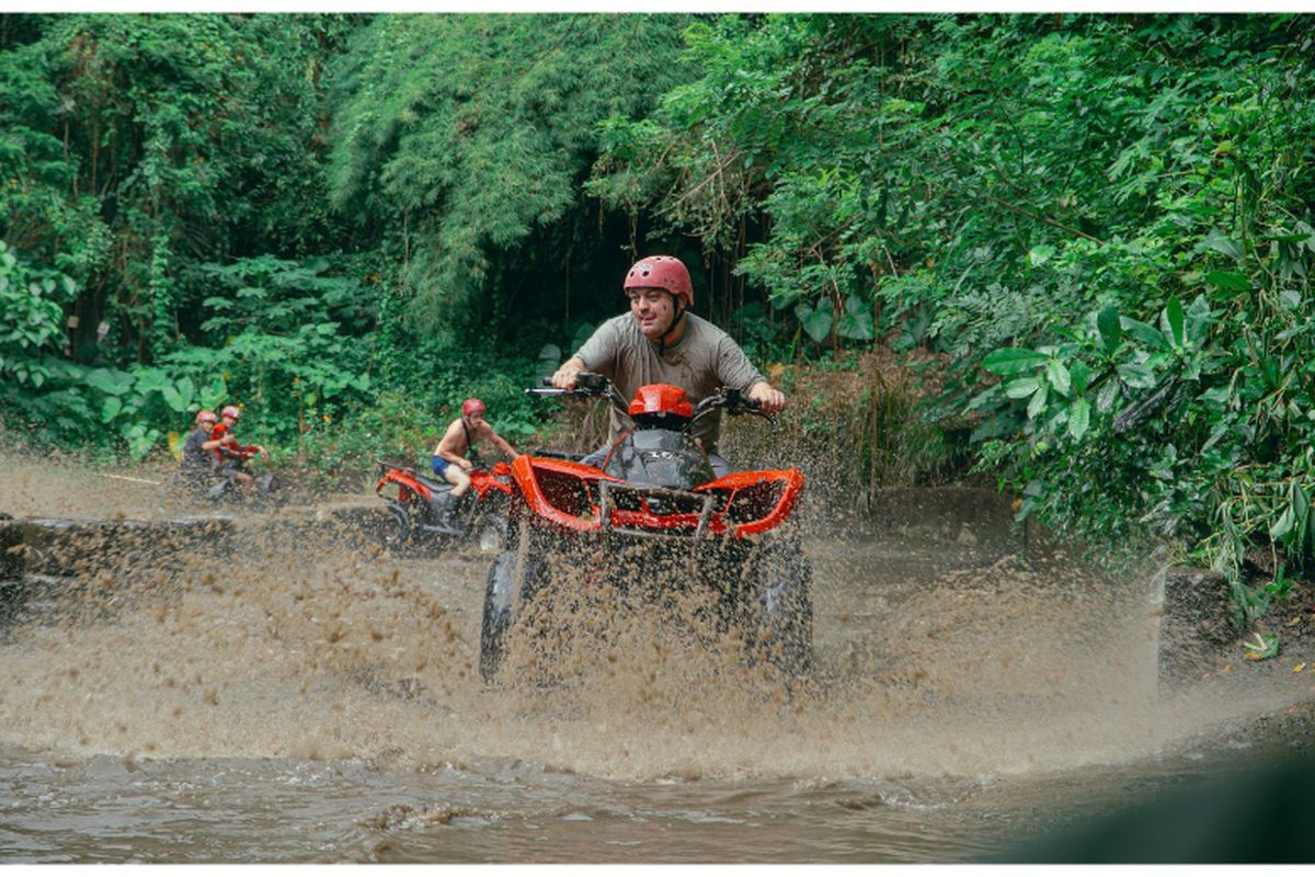 Wisatawan menikmati serunya melintasi jalur berlumpur dengan ATV Quad Bike di kawasan Ubud, Bali