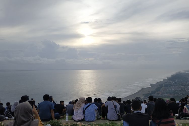 Suasana di Bukit Paralayang Watugupit, Yogyakarta. Wisatawan tengah menikmati pemandangan ke arah pantai selatan dan Samudera Hindia.