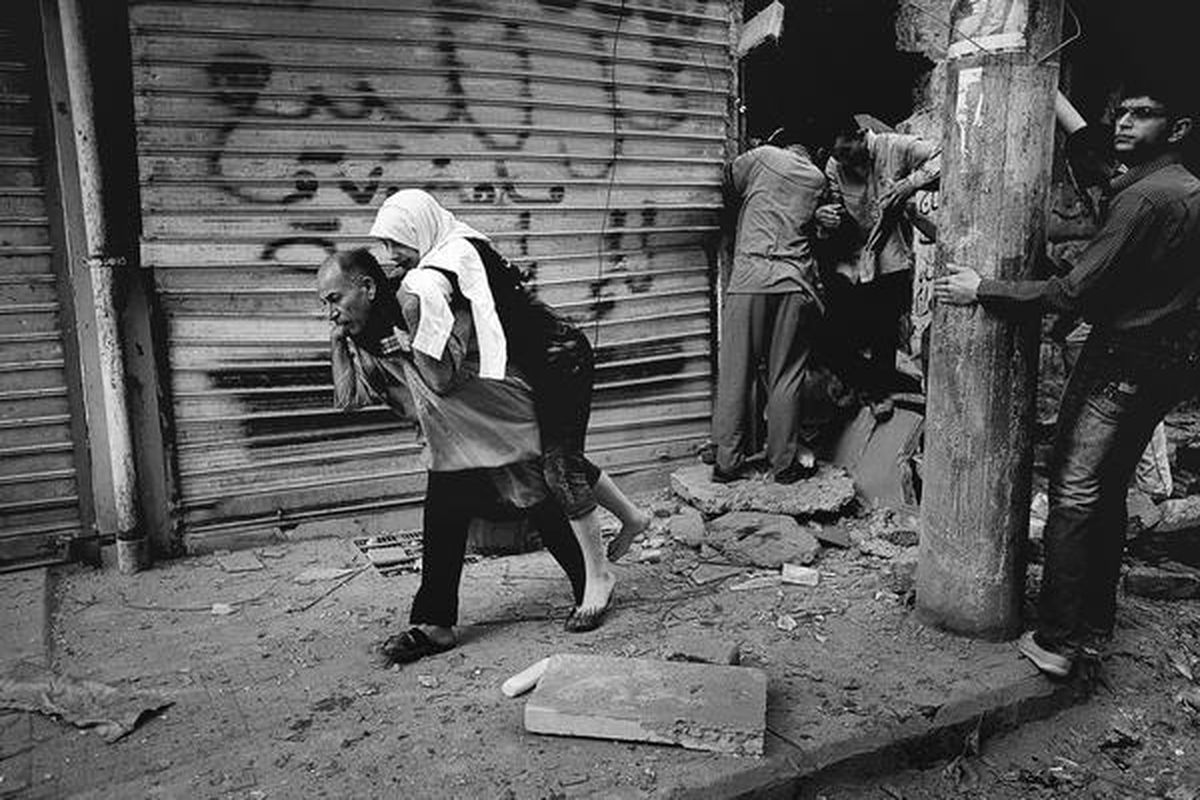 Warga menggendong seorang perempuan yang baru saja dikeluarkan dari rumahnya yang hancur di distrik Shaar, kota Aleppo, Suriah, Sabtu (13/10). Pasukan pemerintah merebut kembali distrik itu dari tangan pasukan oposisi pada hari Minggu (14/10) setelah melalui pertempuran sengit.