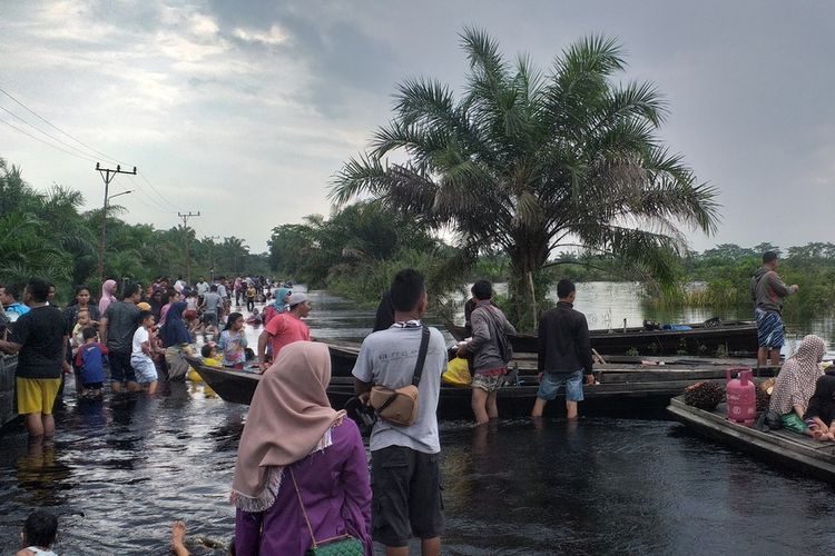 Ratusan warga wisata ke lokasi banjir untuk mengisi hari libur Natal dan Tahun Baru di Desa Buluh Cina, Kecamatan Siak Hulu, Kabupaten Kampar, Riau, Rabu (25/12/2019) sore.