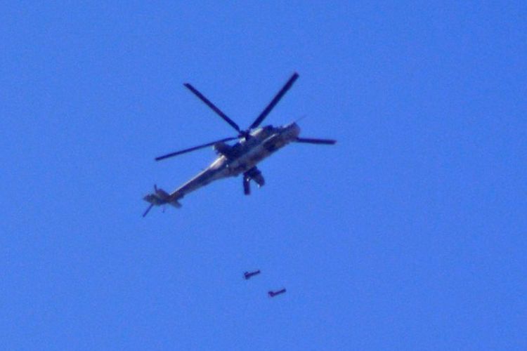 Helikopter MI24 tentara Suriah melepaskan bom barel di atas Damaskus selatan di area kamp pengungsi Palestina Yarmuk pada 27 April 2018.