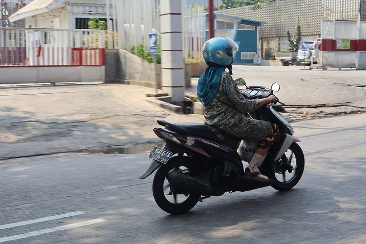 Pengendara wanita saat berkendara di jalan.