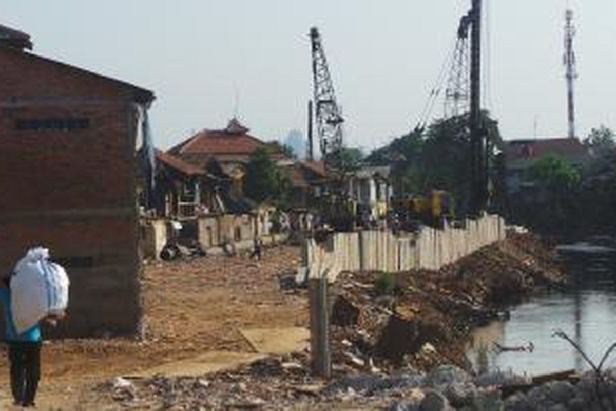 Alat berat sedang bekerja di lahan bekas pemukiman Kampung Pulo yang digusur di pinggiran Sungai Ciliwung. Senin (31/8/2015).