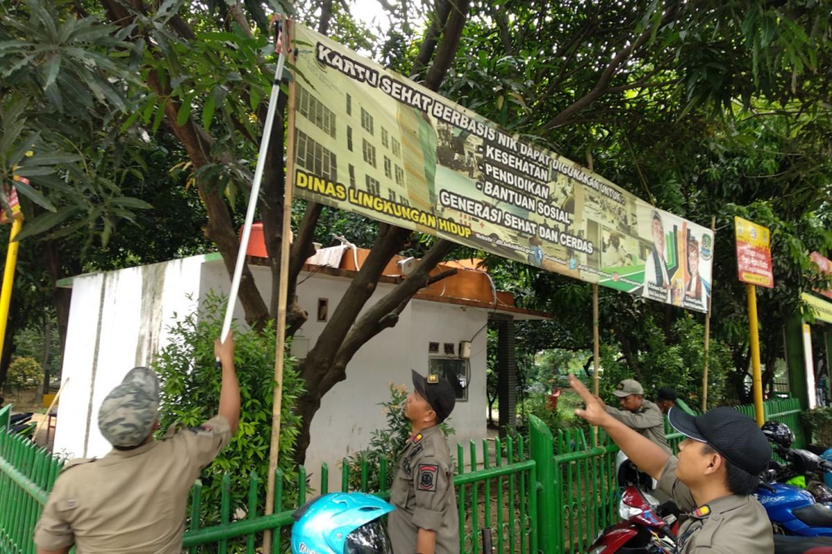 Satpol PP kota Bekasi menertibkan spanduk APK, Rabu (21/2/2018). 