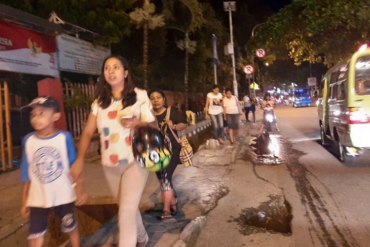Seornag ibu membawa tas memegang tangan anaknya pergi ke lokasi ketinggian saat gempa bermagnitudo 5,1 mengguncnag Ambon, Selasa malam (12/11/2019)