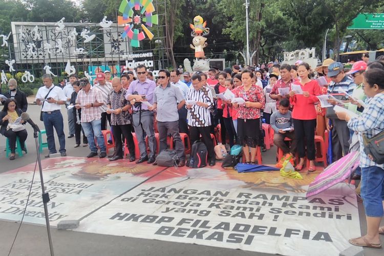 Sekitar 120 jemaat dari GKI Yasmin dan HKBP Filadelfia menggelar ibadah Minggu di seberang Istana Merdeka, Jakarta, pada Minggu (12/11/2017) karena dua gereja mereka masih disegel oleh pemerintah daerah setempat.