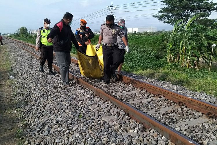 Petugas mengevakuasi jenazah korban yang tertabrak kereta api di jalur kereta api Desa Gampengrejo, Kabupaten Kediri, Jawa Timur, Rabu (6/10/2021).