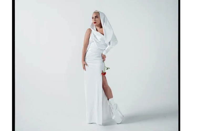 Lady Gaga terlihat memakai heels setinggi 20 centimeter berwarna putih yang dipadukan gaun dengan belahan setinggi paha berwarna senada.