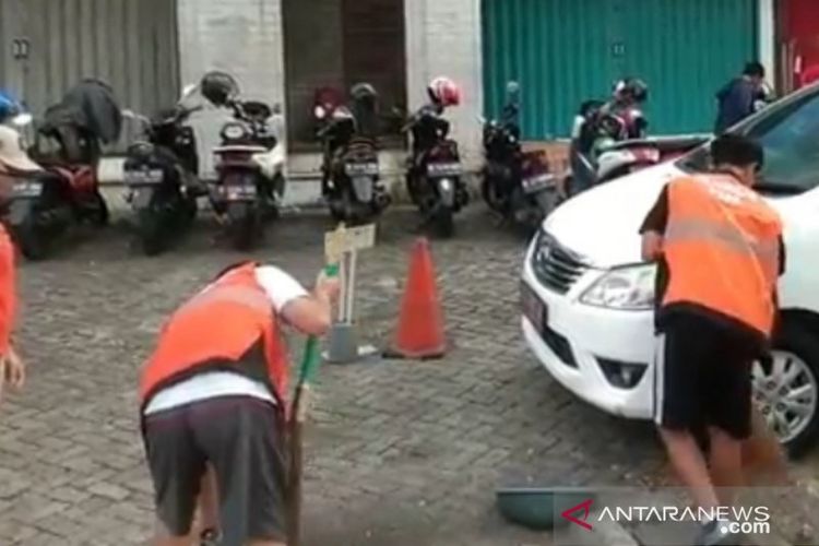 Peserta CFD di Jalan Pemuda, Rawamangun, Jakarta Timur, disanksi menyapu dan memungut sampah di jalan karena hadir tidak menggunakan masker, Minggu (28/6/2020).