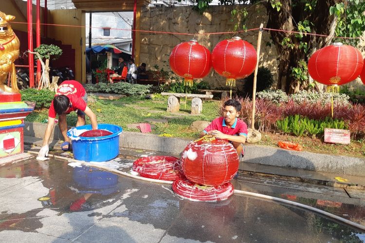 Petugas dari Wihara Dharma Bakti membersihkan lampion di halaman Wihara, Jumat (17/1/2020)