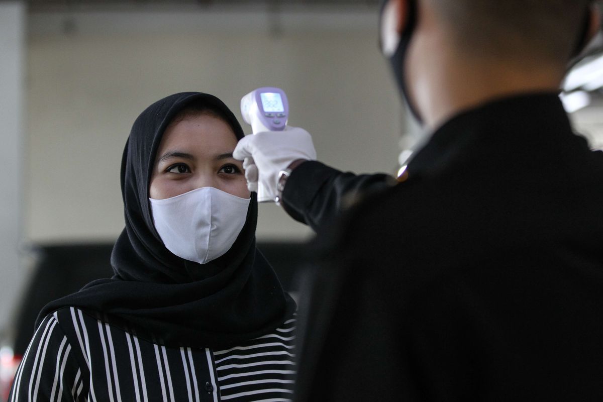 Petugas mengukur suhu tubuh tamu di Hotel Santika Depok, Selasa (9/6/2020). Sebanyak kurang lebih 80 unit hotel jaringan Santika Indonesia Hotels dan Resorts mulai dibuka sejak 4 Juni 2020 dengan menerapkan protokol kesehatan kenormalan baru untuk mencegah penyebaran virus Covid-19.