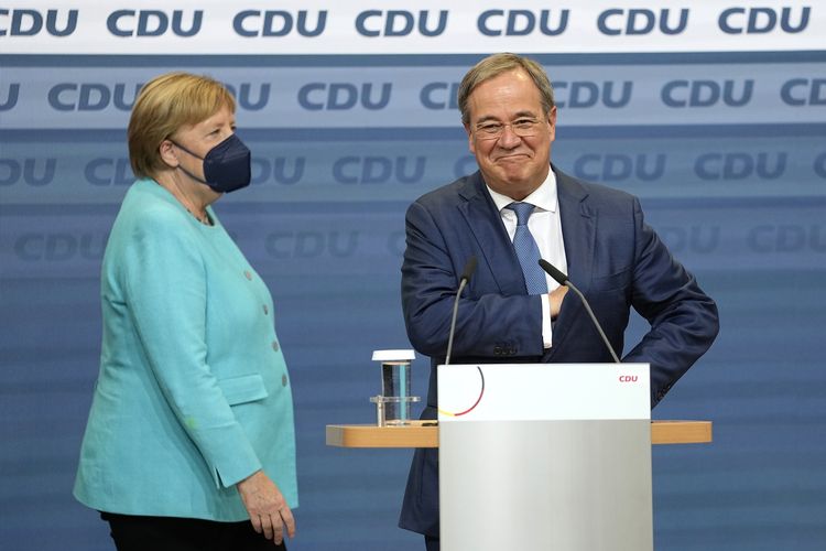 Kanselir Angela Merkel berdiri di sebelah Gubernur Armin Laschet (kanan), kandidat kuat dari Christian Democratic Union (CDU) di pemilu Jerman, saat berada di markas CDU, Berlin, Minggu (26/9/2021).