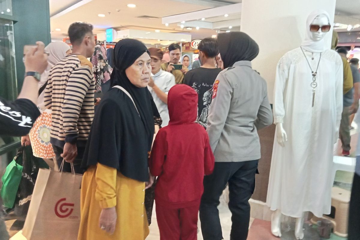 Aipda Marwati saat melakukan patroli keliling memantau situasi sambil menggandeng anaknya dii area Mal Panakkukang, Jalan Boulevard, Kecamatan Panakkukang, Kota Makassar, Sulsel, Sabtu (6/4/2024).