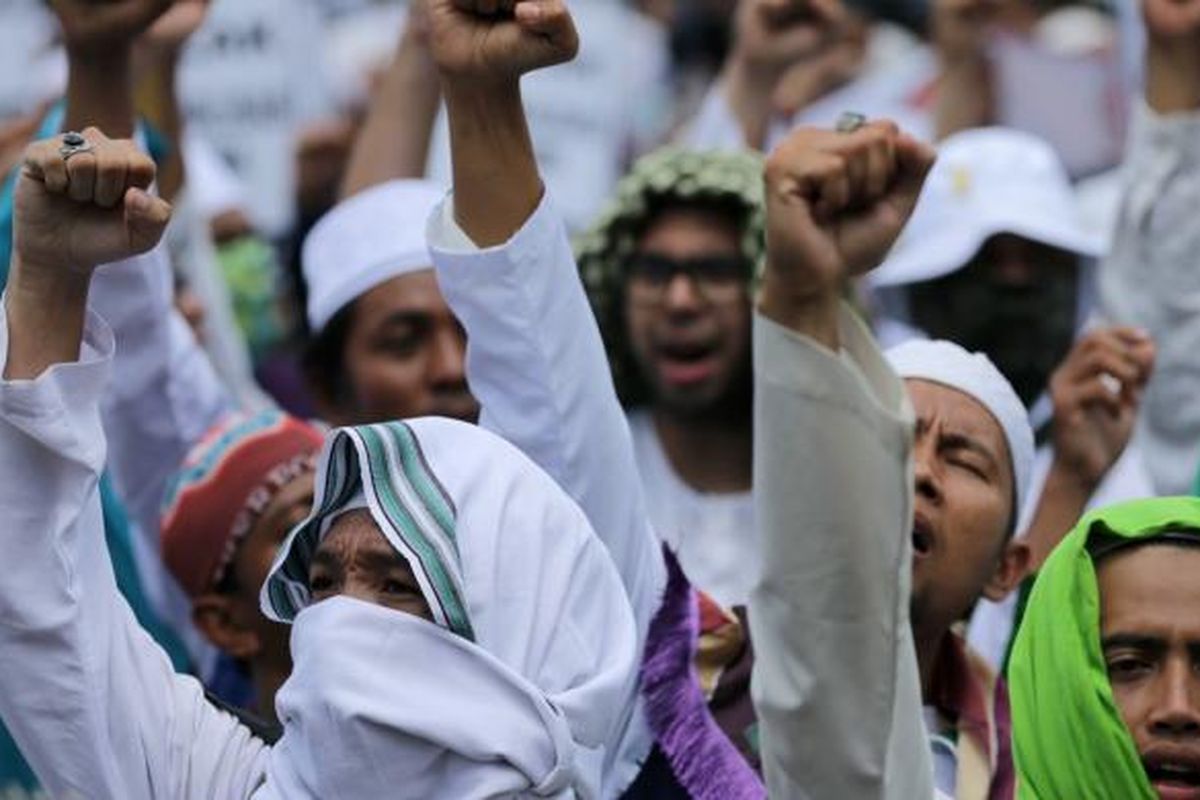 Massa Front Pembela Islam berunjukrasa di depan Polda Metro Jaya, Jakarta, Senin (23/1/2017). Pimpinan FPI Rizieq Shihab diperiksa oleh Subdirekorat Fiskal, Moneter, dan Devisa Direktorat Reserse Kriminal Khusus Polda Metro Jaya, terkait ucapannya soal gambar palu arit di logo Bank Indonesia dalam lembaran uang rupiah. KOMPAS IMAGES/KRISTIANTO PURNOMO