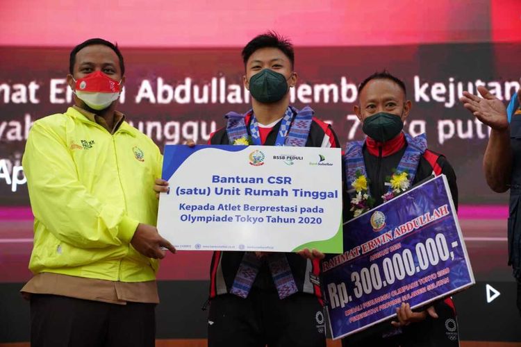 Pelaksana Tugas (Plt) Gubernur Sulsel, Andi Sudirman Sulaiman memberikan hadiah kepada atlet angkat besi asal Sulawesi Selatan (Sulsel), Rahmat Erwin Abdullah peraih medali perunggu pada Olimpiade Tokyo 2020 berupa sebuah rumah dan uang tunai Rp 300 Juta.