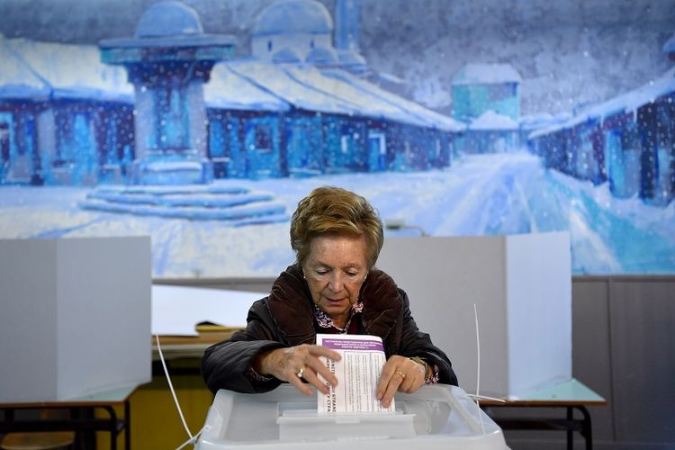 Seorang perempuan memberikan suaranya dalam pemilihan umum di sebuah TPS di ibu kota Sarajevo, Minggu (7/10/2018).