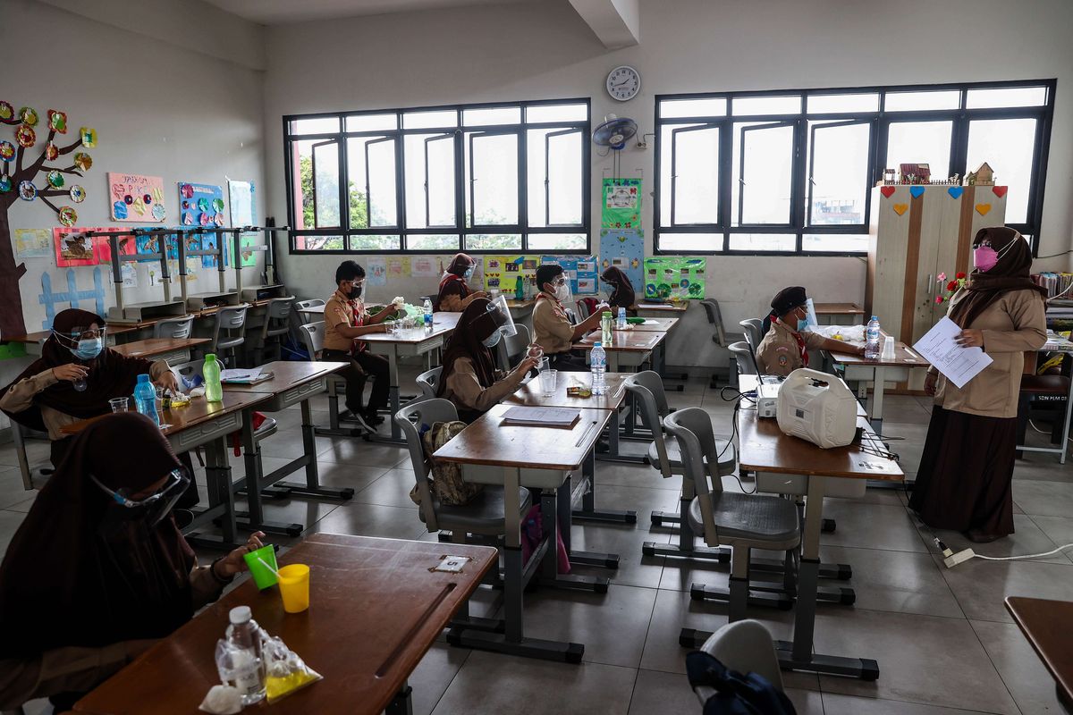 Guru memberikan materi pelajaran kepada murid saat uji coba pembelajaran tatap muka pada hari pertama di SDN 03 Palmerah, Jakarta Barat, Rabu (7/4/2021). Pemprov DKI Jakarta melakukan uji coba pembelajaran tatap muka terbatas di 85 sekolah dari jenjang SD hingga SMA mulai 7 April hingga 29 April 2021 dengan kapasitas dalam ruangan maksimum 50 persen dan penerapan protokol kesehatan yang ketat.