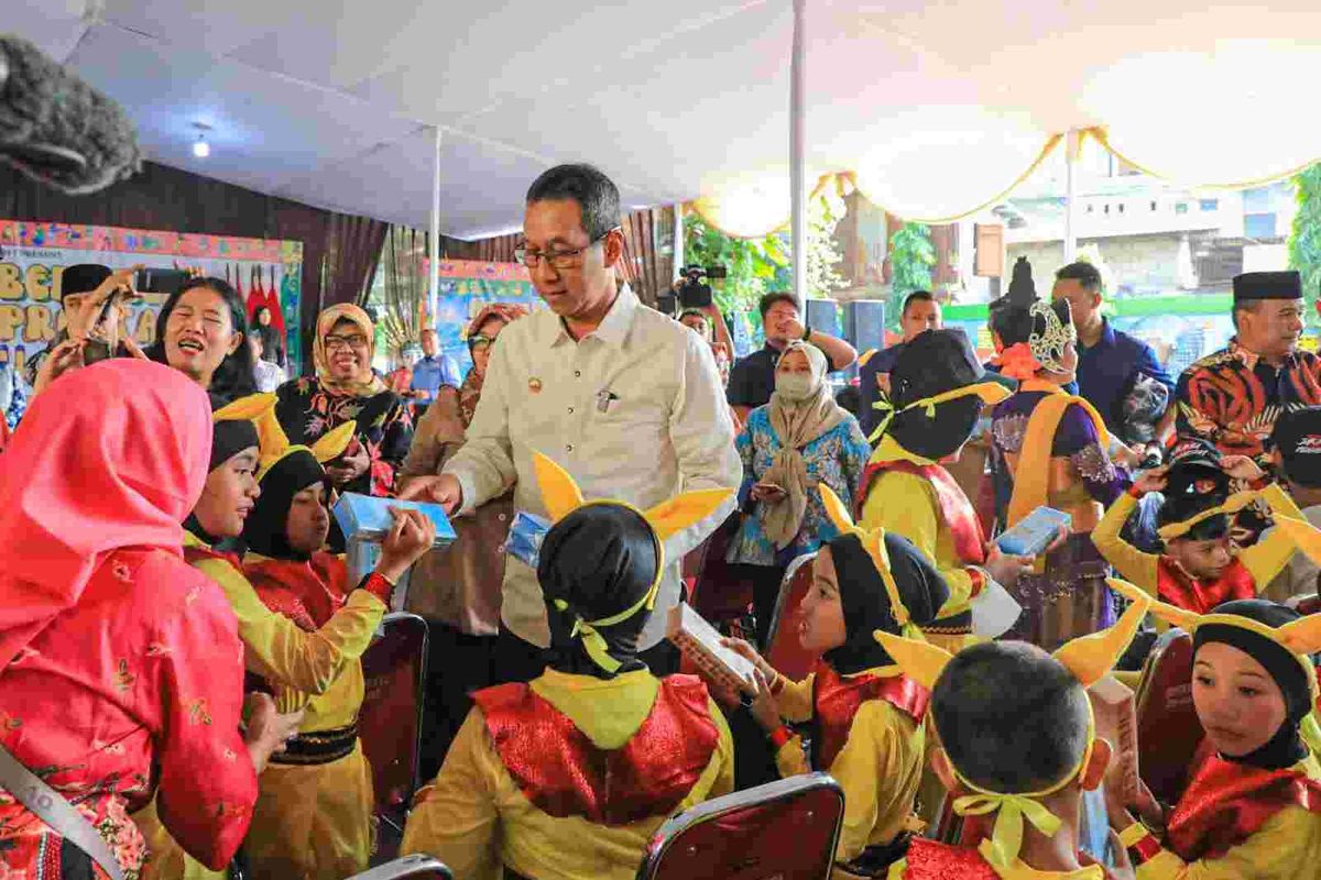 Pj Gubernur DKI Jakarta Heru Budi Hartono membagikan alat tulis kepada para siswa SLB Negeri 7 Jakarta,  Rabu (13/12/2023).