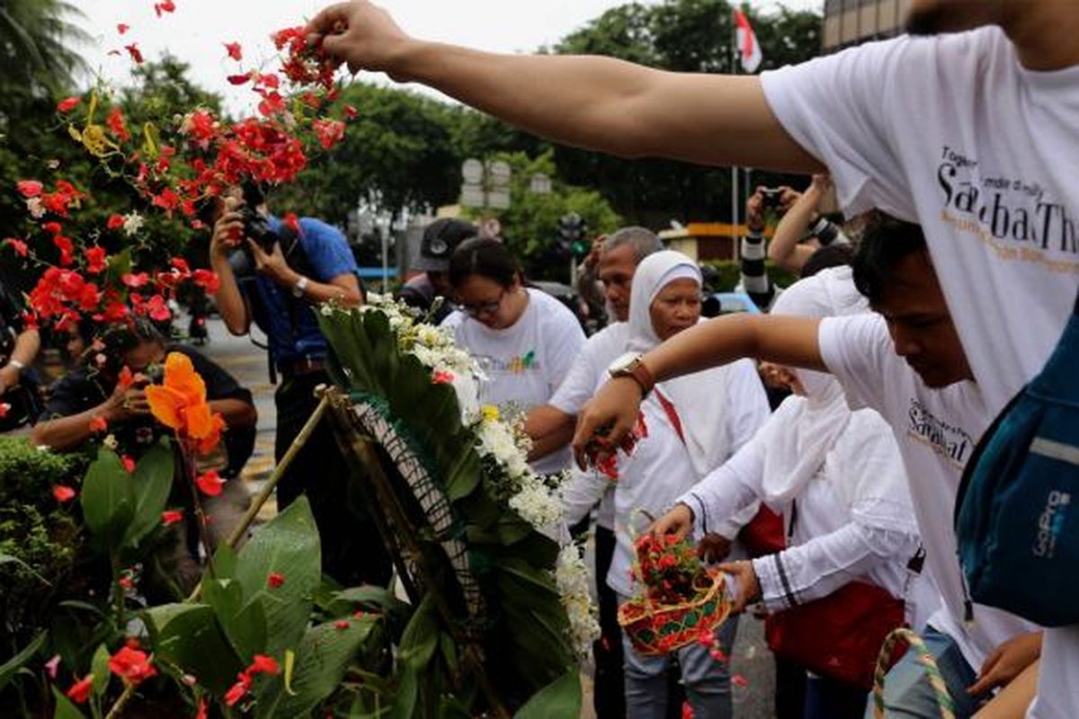 Massa yang tergabung dalam Sahabat Thamrin, Yayasan Penyintas, dan Aliansi Indonesia Damai (AIDA) melakukan tabur bunga di Sarinah, Thamrin, Jakarta, Sabtu (14/1/2017). Mereka mengenang kembali aksi terorisme yang terjadi siang hari tepat setahun lalu.